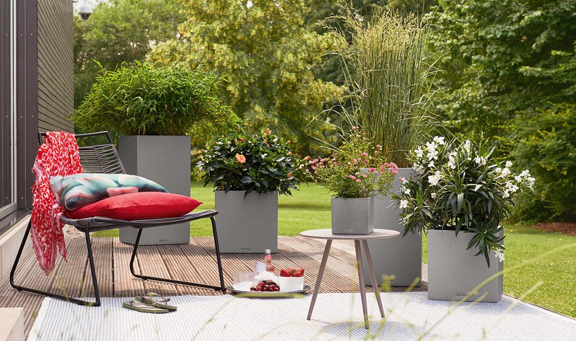 Several planters from the LECHUZA Stone Collection are planted on a terrace