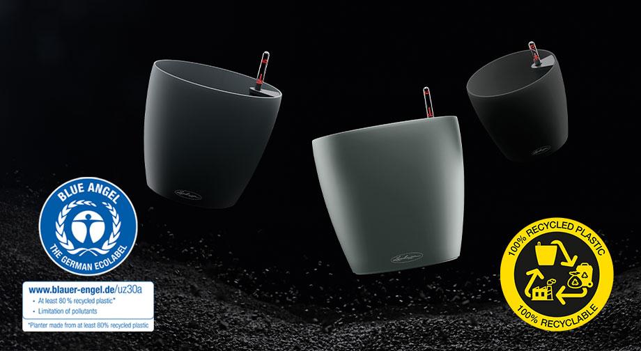 Three LECHUZA planters on a black background with sustainability seal.