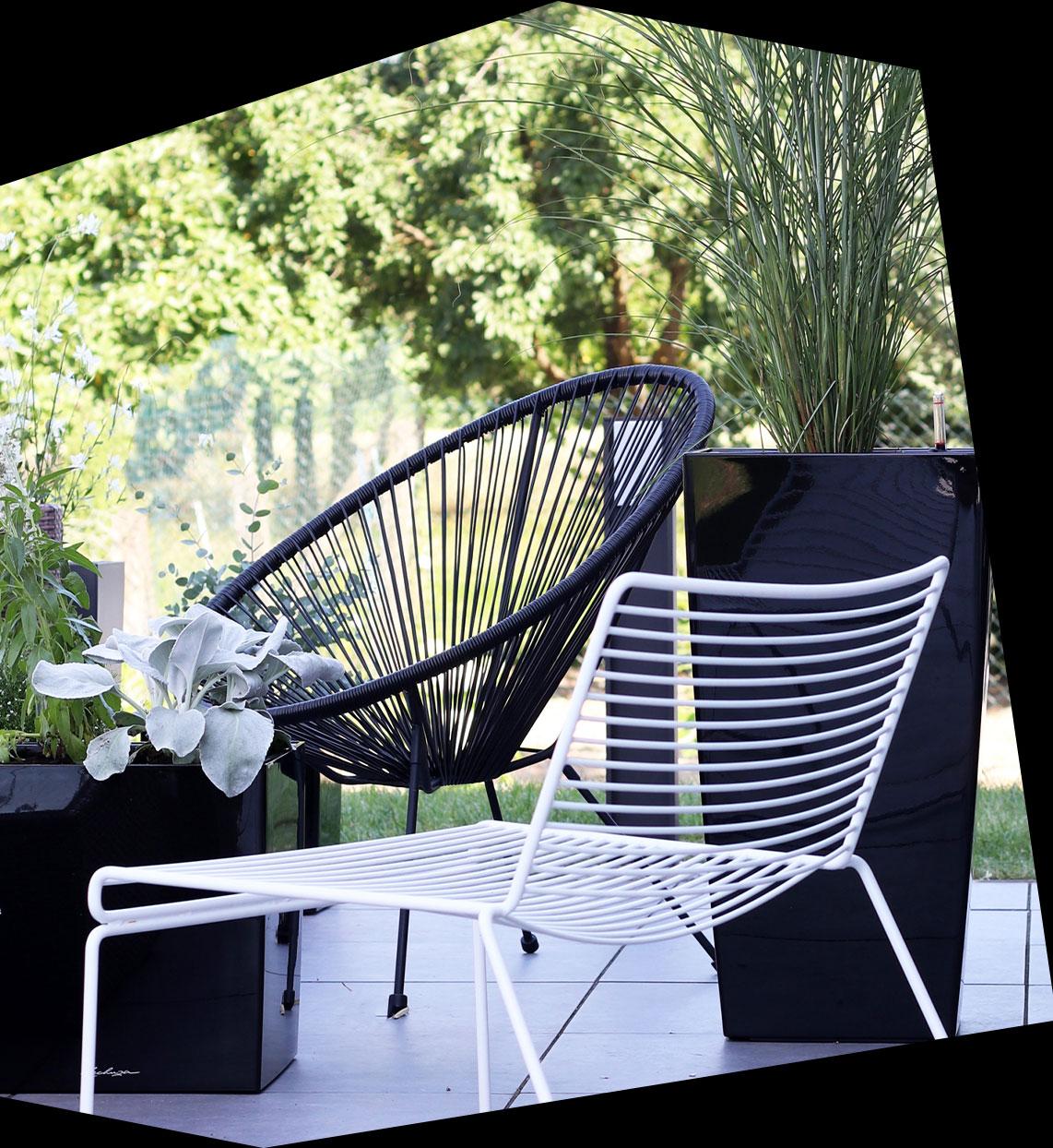 Schwarzes Hochglanz-Pflanzgefäß CUBICO und CUBE auf einer Terrasse mit schwarzen und weißen Stahlrohrmöbeln.