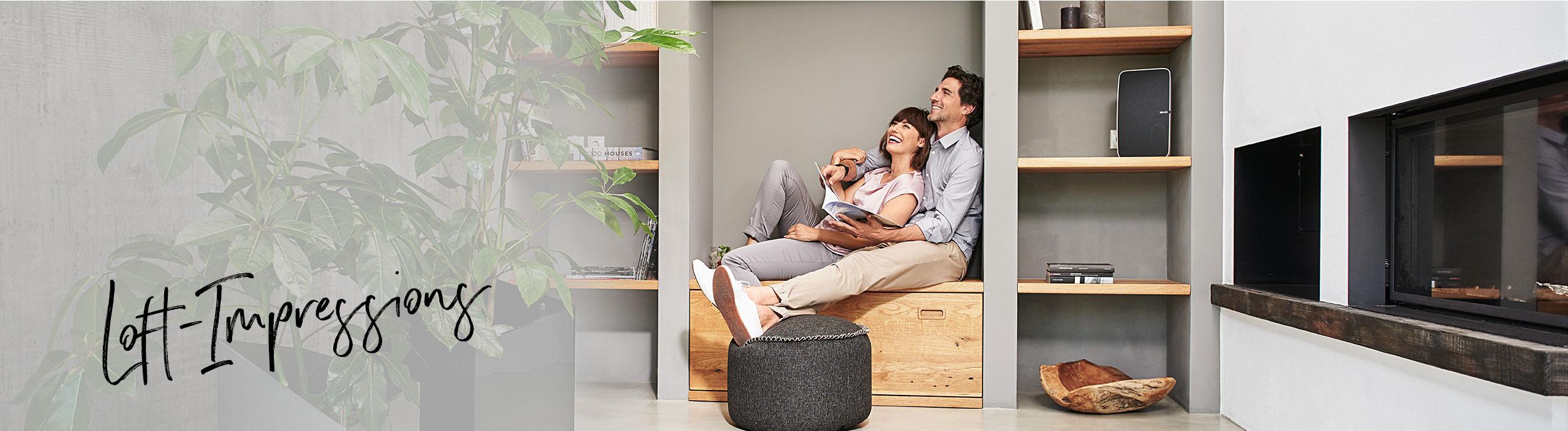 Couple sitting comfortably in a built-in niche in a modern loft flat