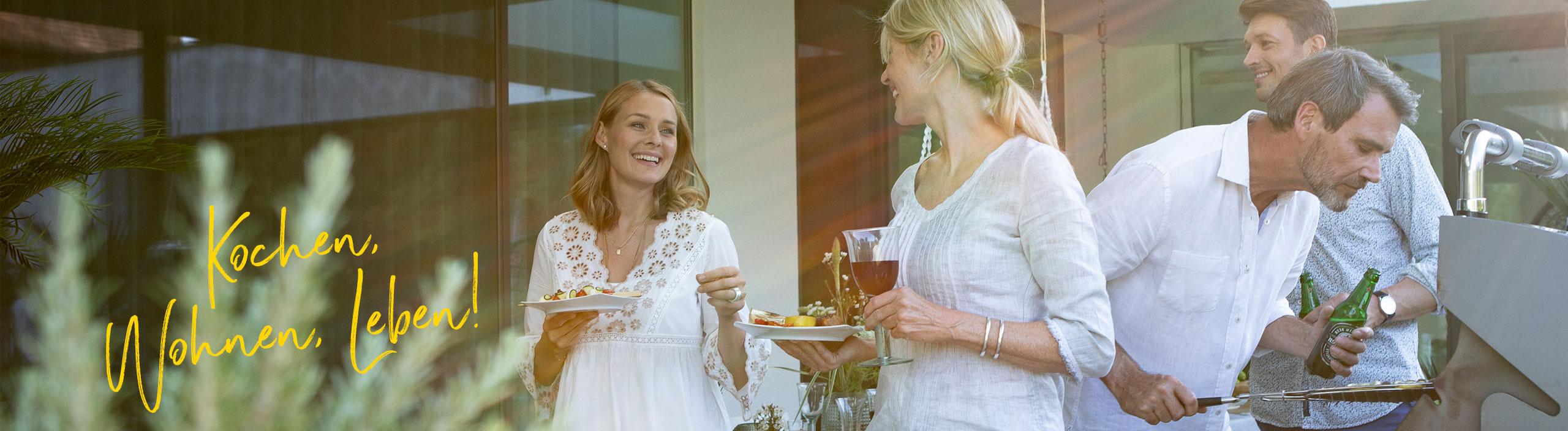 Vier Freunde grillen gemeinsam und unterhalten sich dabei.