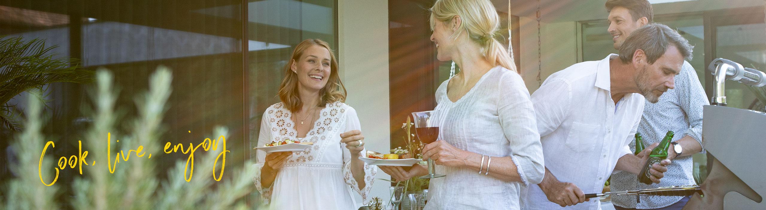 Four friends enjoying a barbecue together and talking.