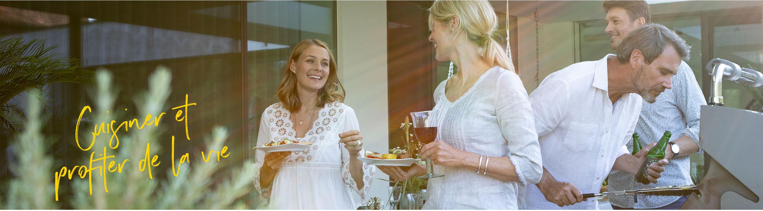 Quatre amis font des grillades ensemble et discutent.