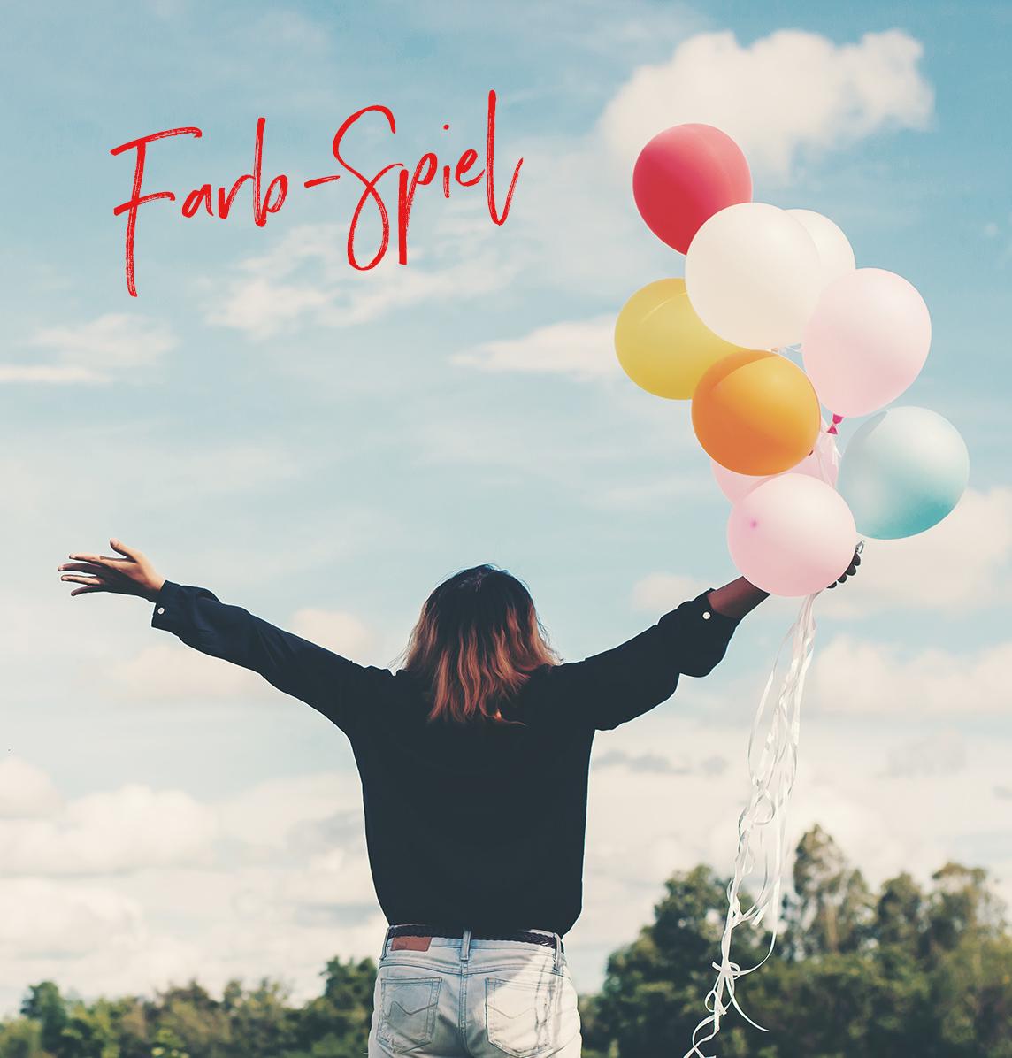 Mädchen auf einem Feld mit bunten Luftballons