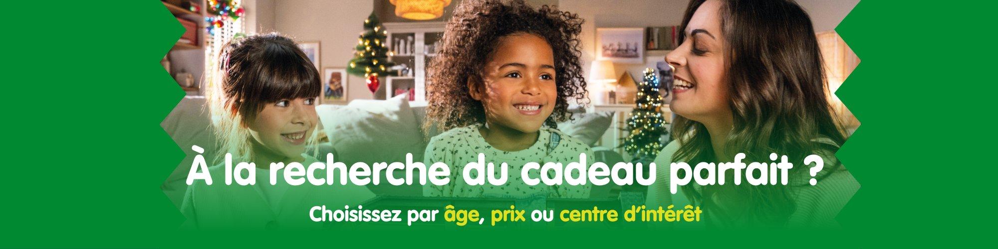 Deux enfants et une femme sourient dans un salon d&eacute;cor&eacute; pour No&euml;l &ndash; d&eacute;couvrez les id&eacute;es cadeaux parfaites pour les enfants.